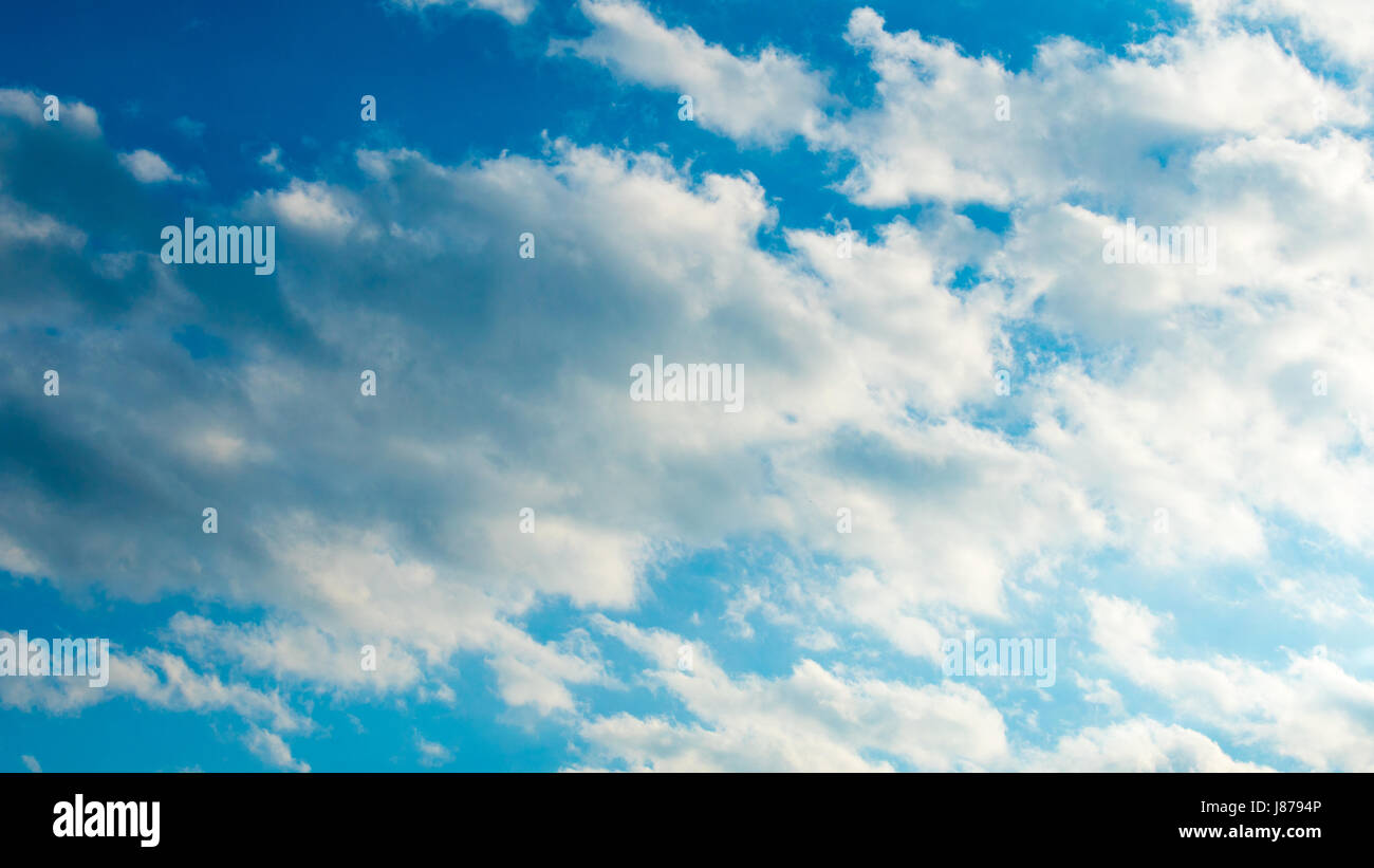 Blue sky with puffy white clouds Stock Photo - Alamy