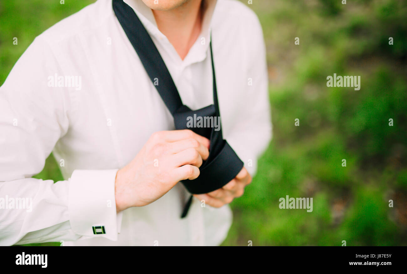 Man tying his tie. The groom tying his tie. Wedding groom accessories ... - Tying A Tie For A Groom Party