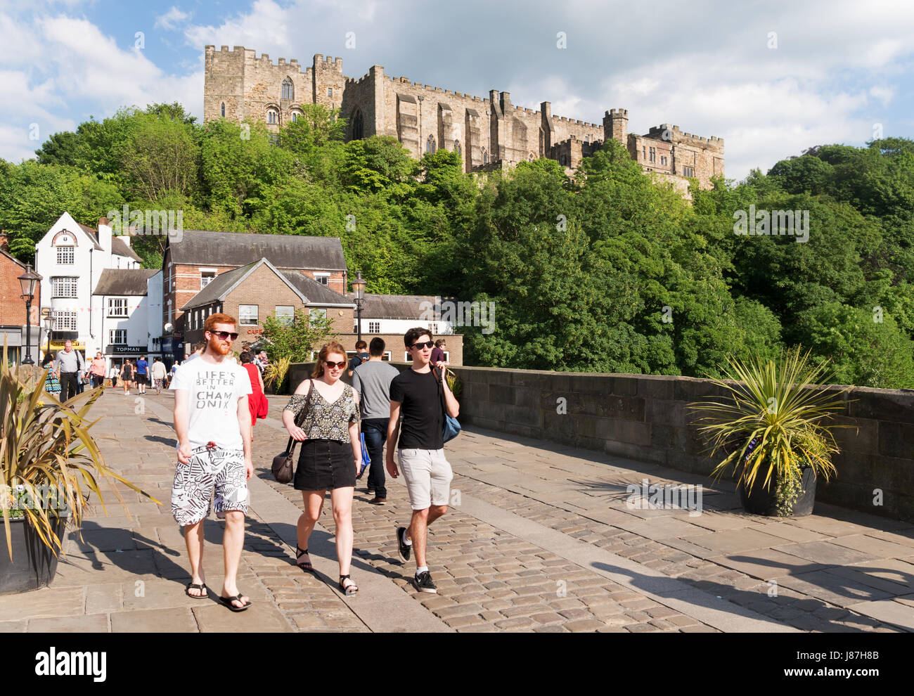 Young people crossing Framwellgate bridge with Durham castle behind, England UK Stock Photo