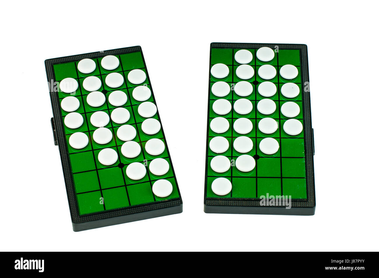 White Broken Heart Shaped Othellos on Separated Green Grid Othello Board Isolated Stock Photo