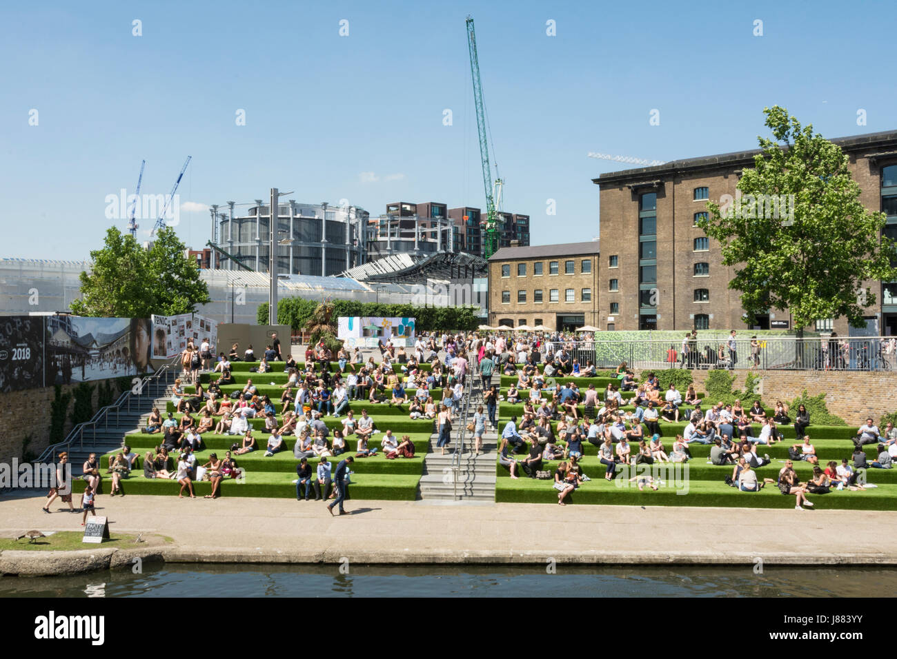 Crowds relaxing in Granary Square, King's Cross, London, England, UK ...
