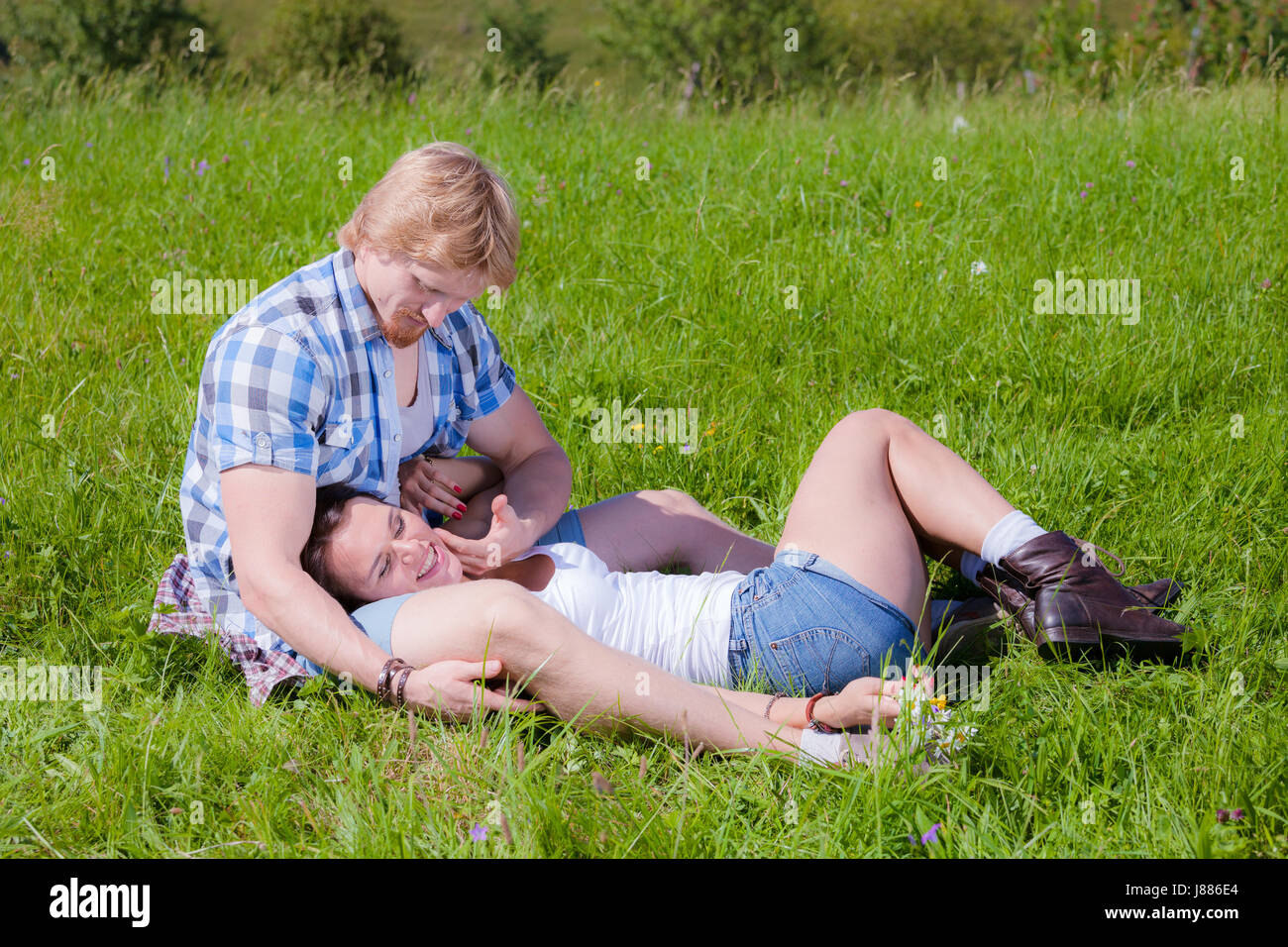 Happy beautiful couple in love on the green grass field Stock Photo - Alamy