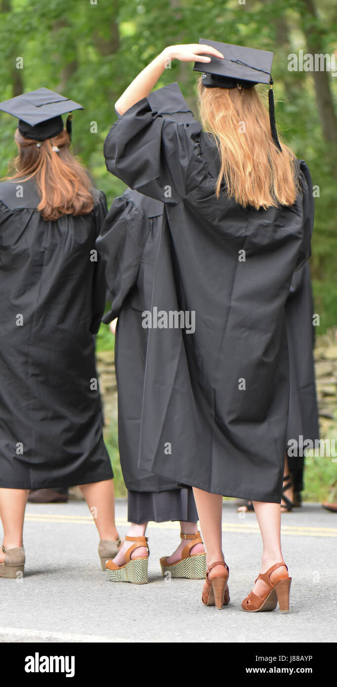 Hand on her mortar board a nervous grad waits in line for graduation. Stock Photo