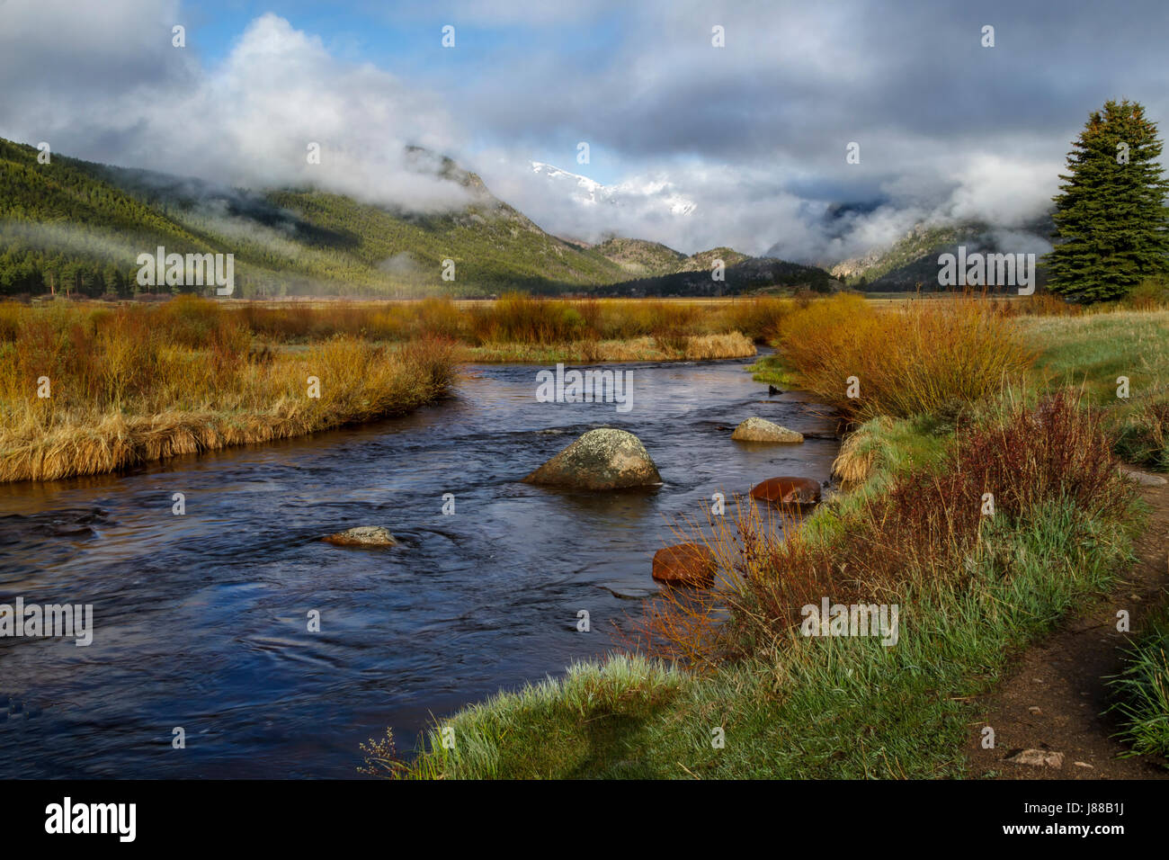 Clouds rolling in on Morraine Park in Rocky Mountain National Park with the Big Thompson flowing in the foreground Stock Photo