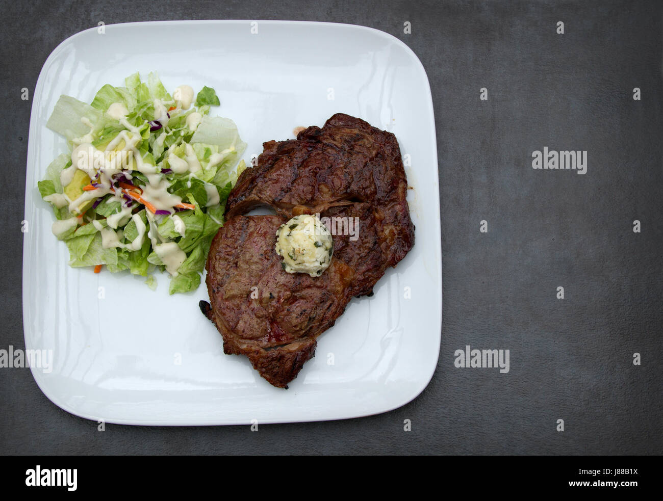 Fat filled Ribeye Steak with Cilantro Butter and a side salad topped