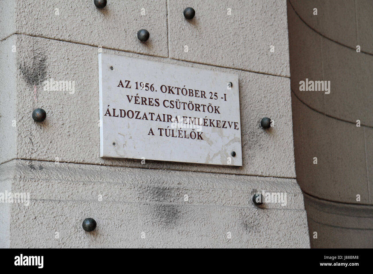 Plaque beside metal pellets marking bullet holes from 1956 revolution on Kossuth Lajos Square in Budapest, Hungary. Stock Photo