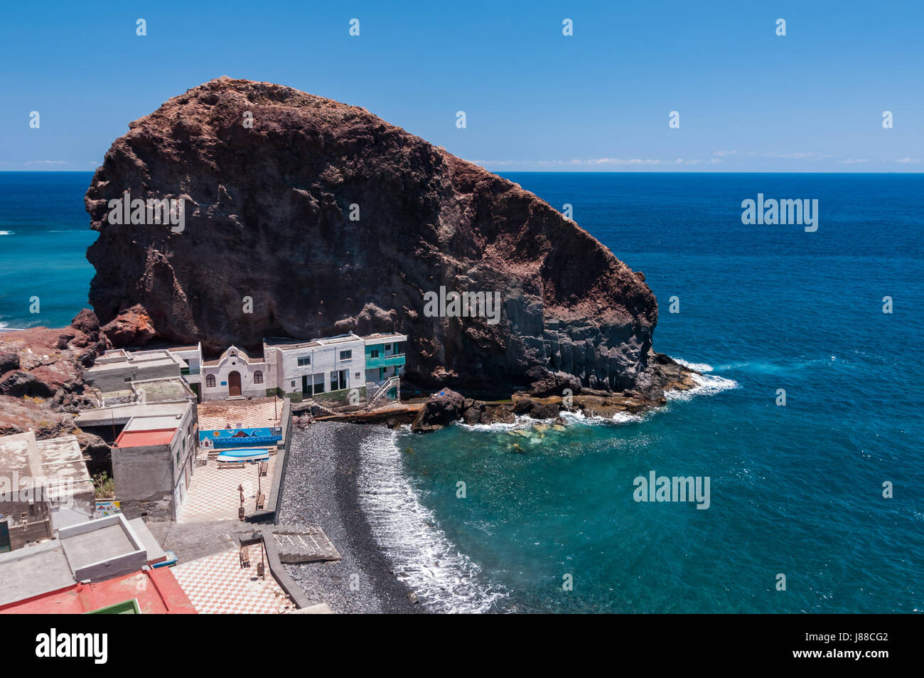 Buildings By Big Rock On Tenerife Coast Stock Photo