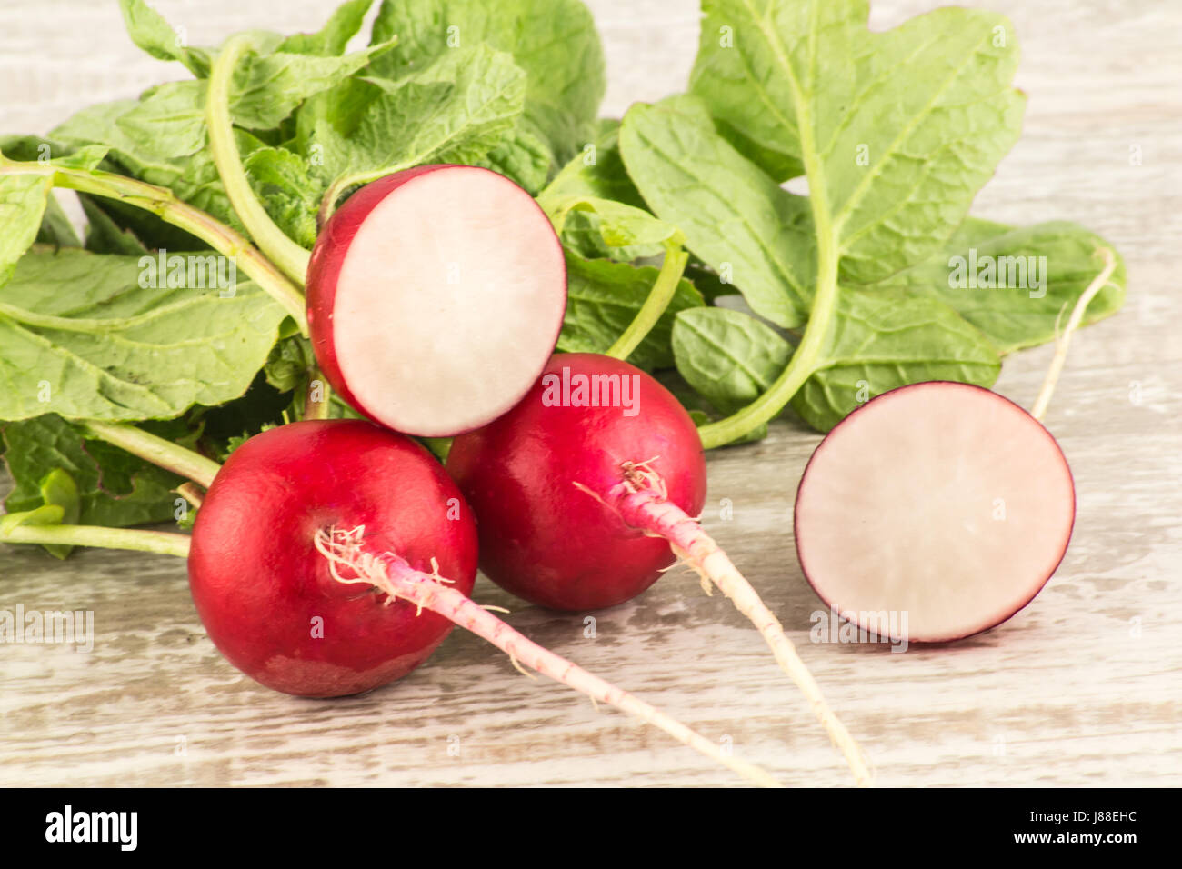 Juicy fresh radish in a cut on a white wooden background close up Stock Photo