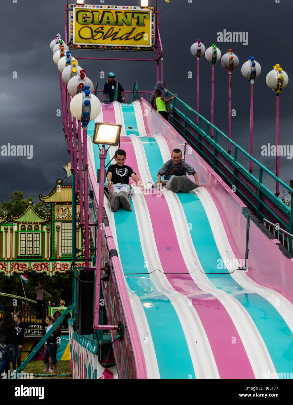 Children playing on a giant slide at the county fair. Stock Photo