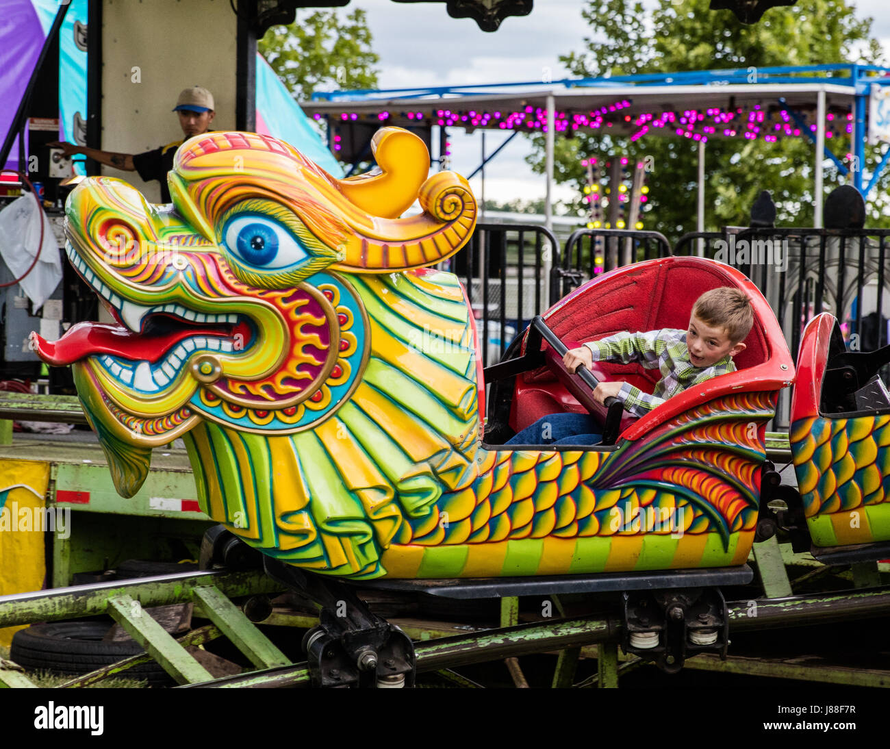 Children and adults enjoying a ride on the midway at the county fair ...