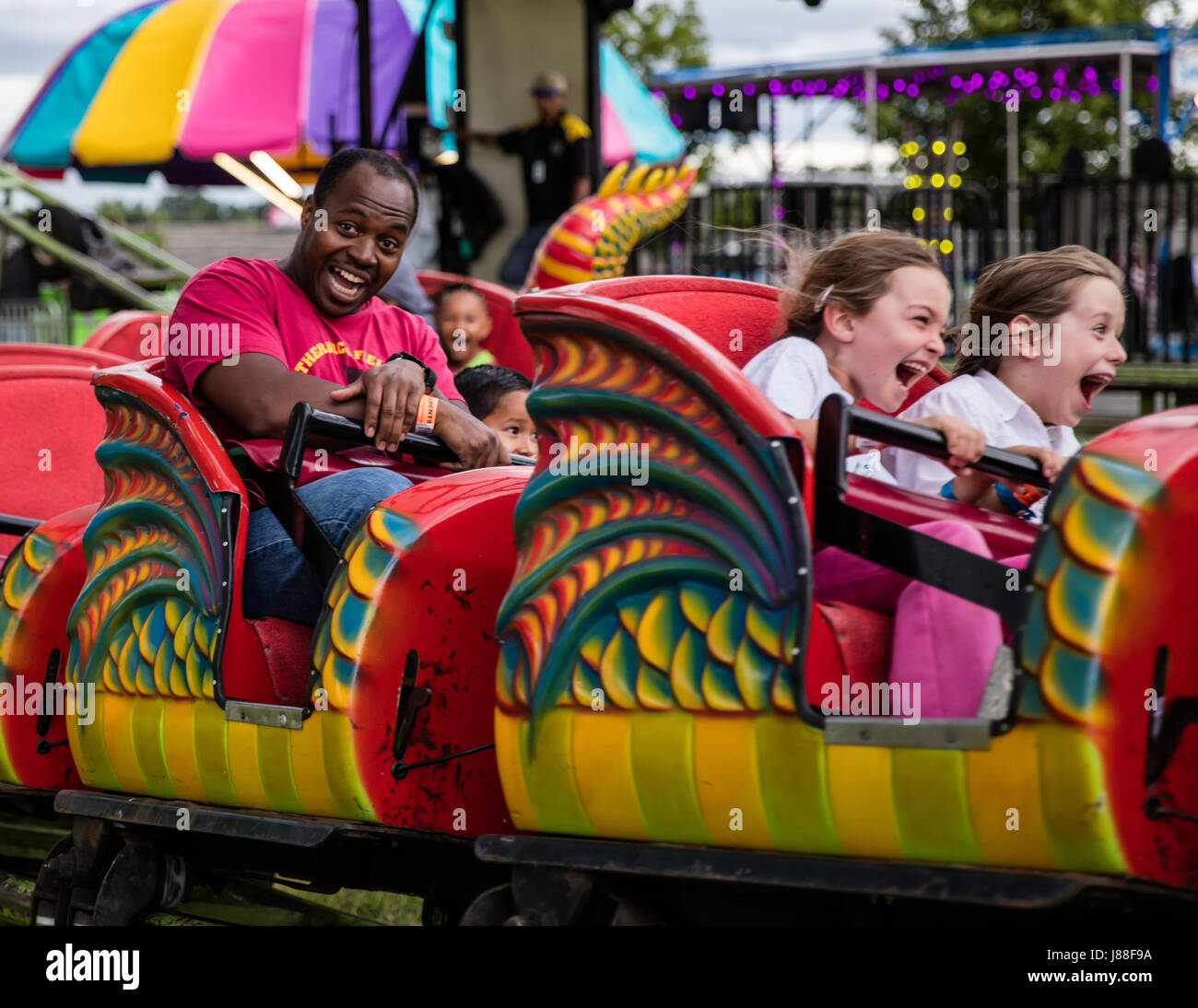 Funfest Children and adults enjoying a ride on the midway at the county fair ...
