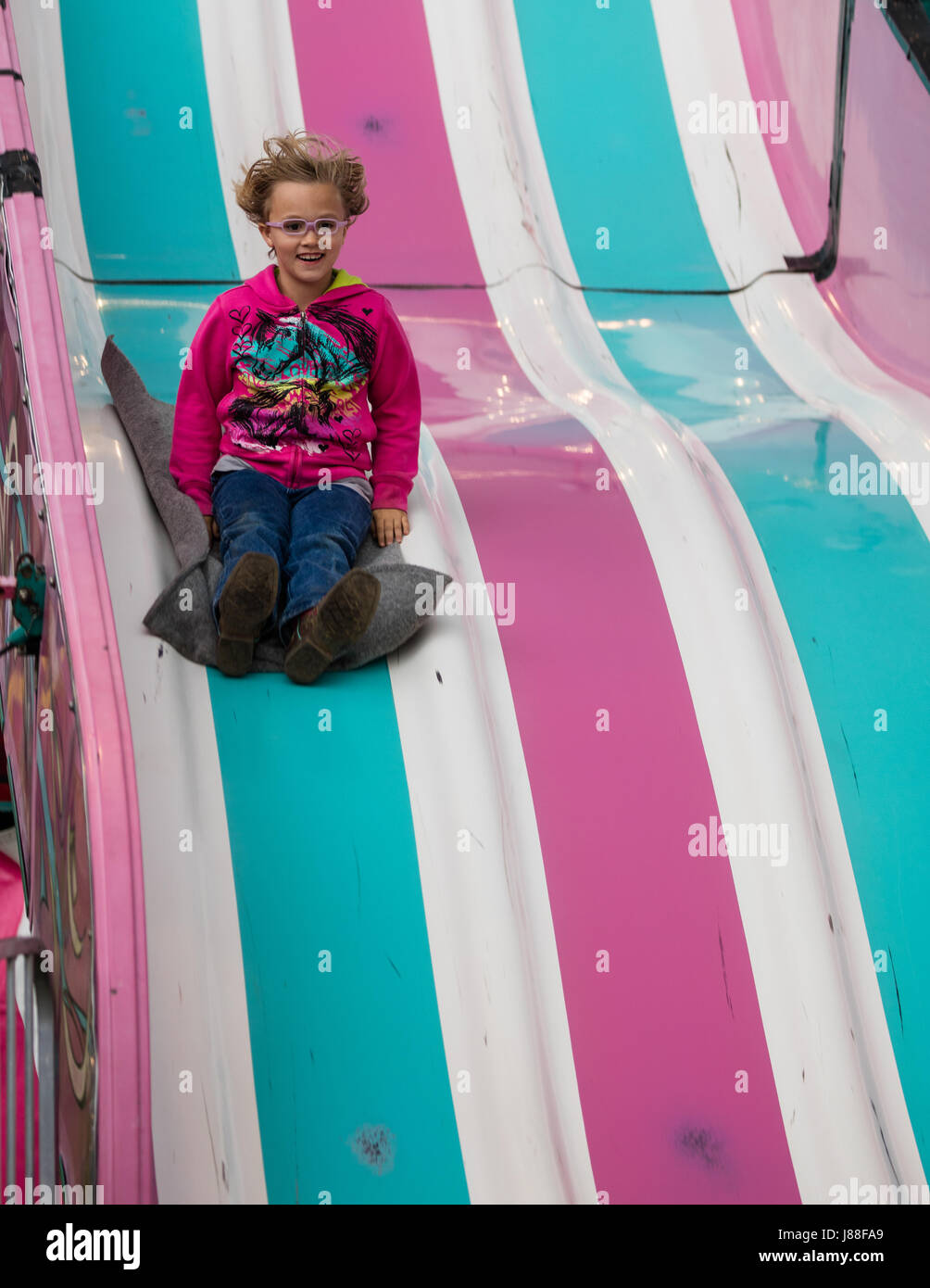 Children playing on a giant slide at the county fair. Stock Photo