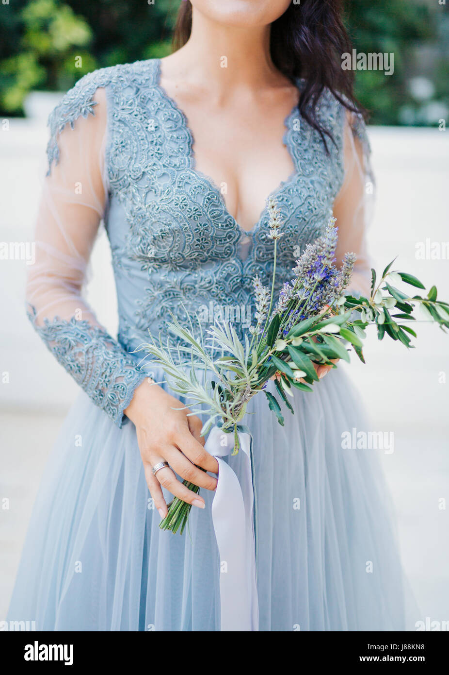 Lavender Wedding Bouquet In Hands Of The Bride In White Blue Dress
