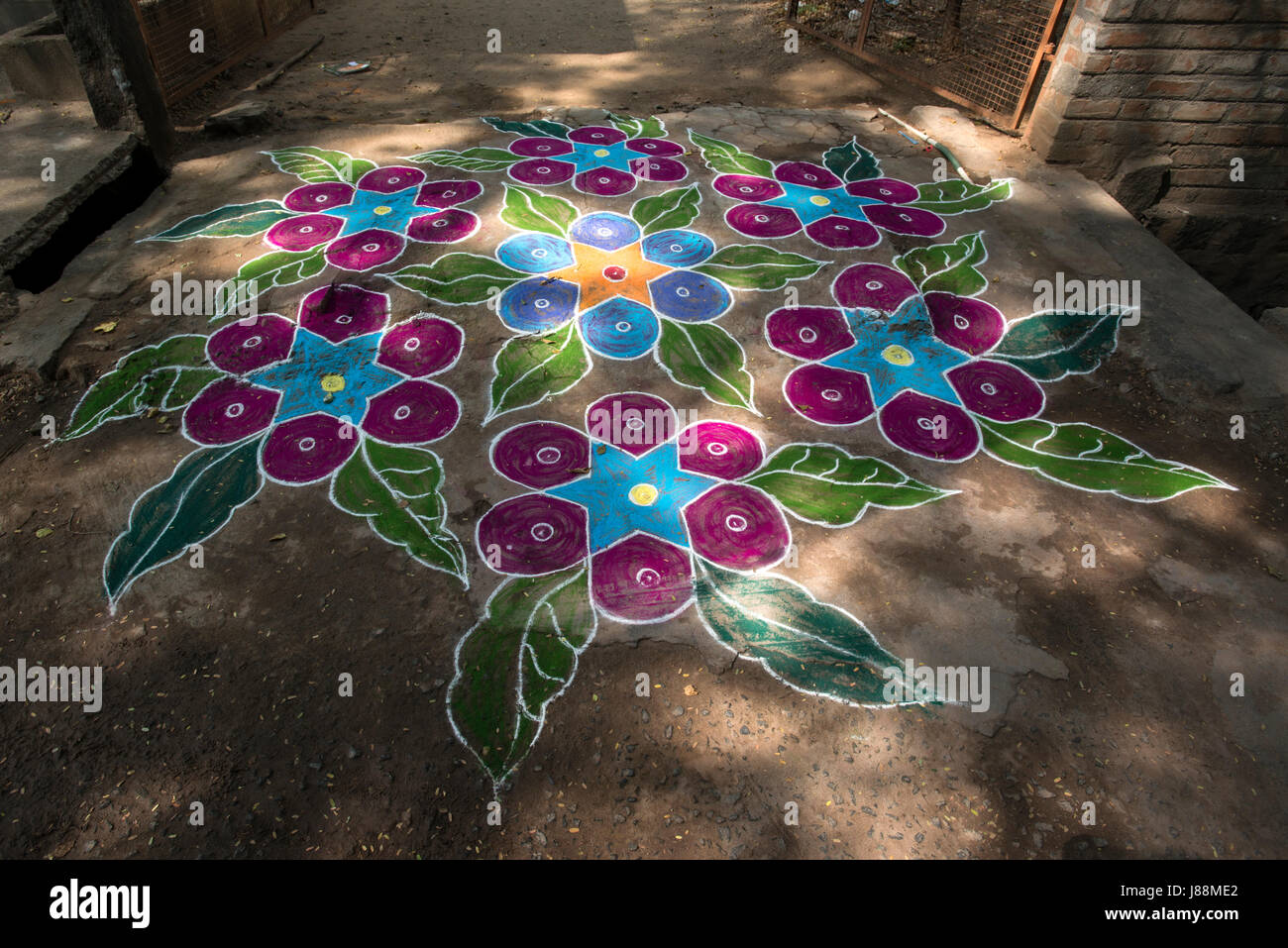 A coloured chalk drawing celebrating the Hindu festival of Pongal adorns a roadway in