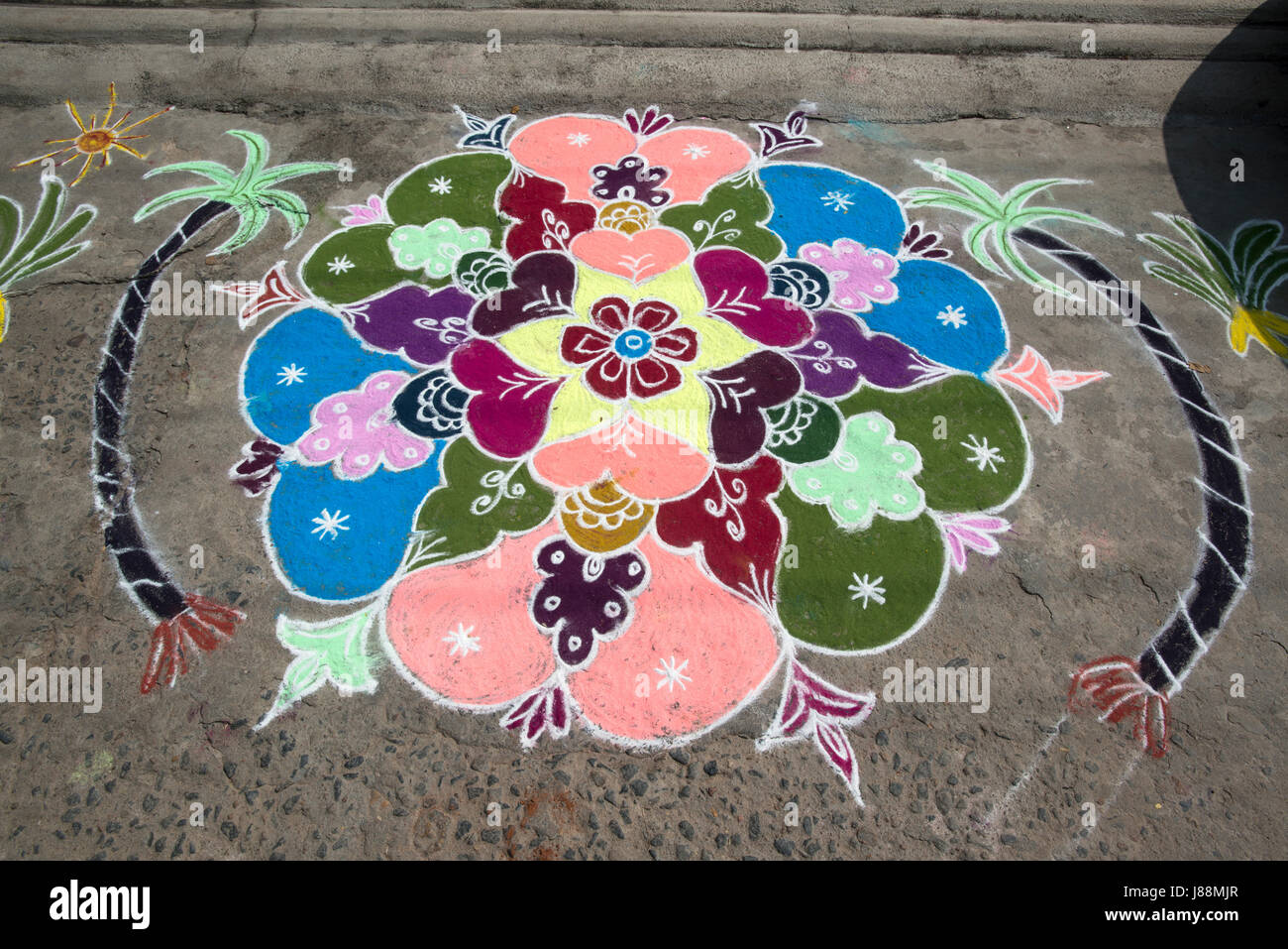 A coloured chalk drawing celebrating the Hindu festival of Pongal adorns a roadway in