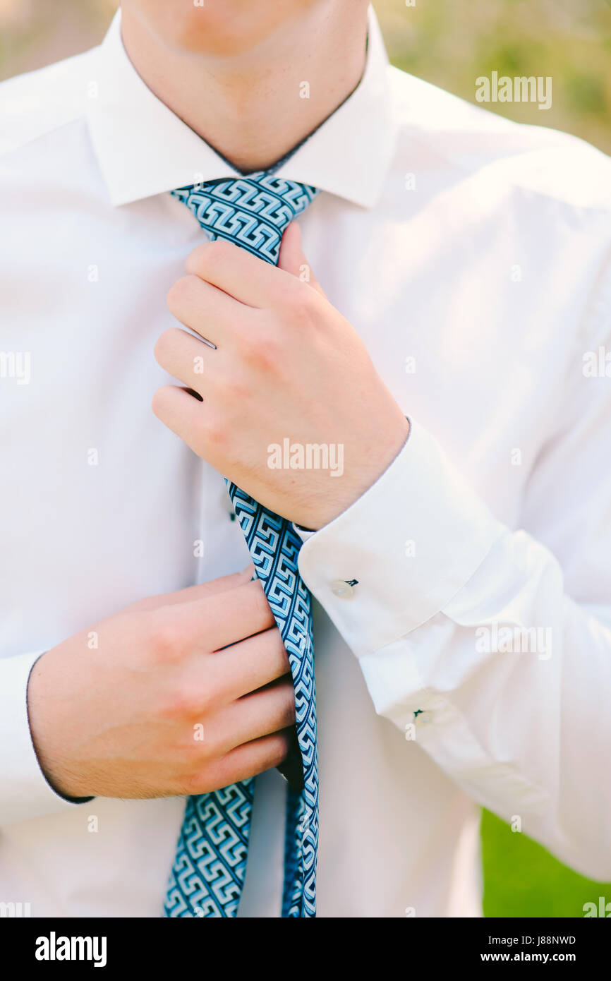 Image showcasing Man tying his tie. The groom tying his tie. Wedding groom accessories ...