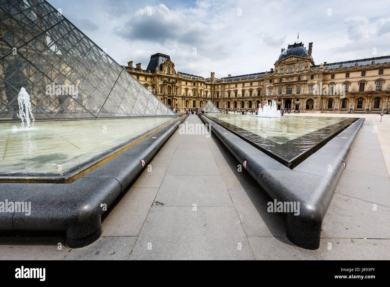 PARIS - JULY 1: Glass Pyramid in Front of the Louvre Museum on July 1, 2013. The Louvre is one of the world's largest museums in Paris. Nearly 35,000  Stock Photo