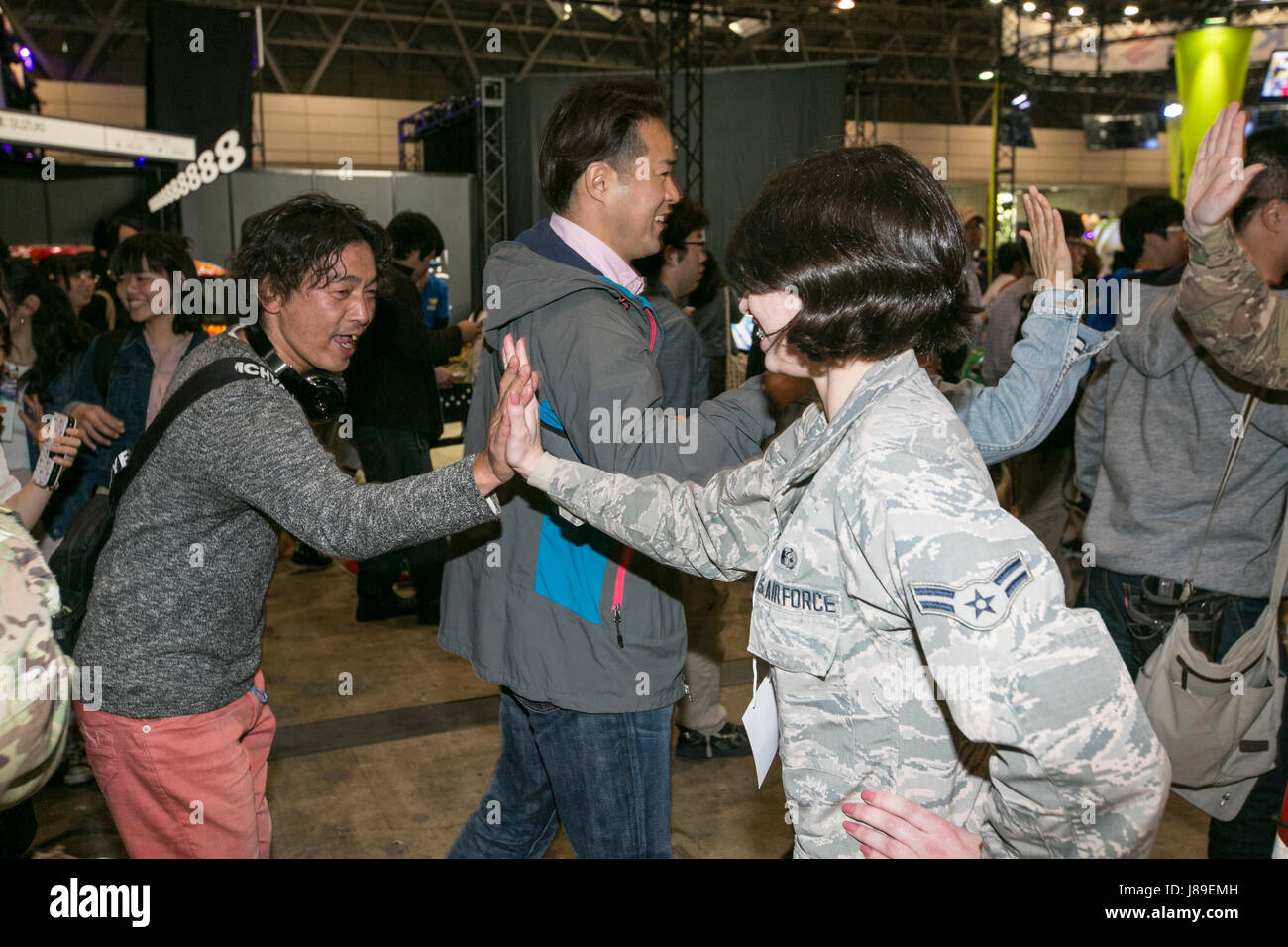 Airman 1st Class Katherine Sirois who is stationed at Camp Zama, Japan gives a high five to a Japanese fan during the opening at Niconico convention. The U.S. Army Japan Soldiers and Air Force airmen were invited to perform in front of fans of nearly 155,000 people and nearly 13 million online viewers. The 'Niconico Festival' is a multicultural entertainment and cosplay convention held annually at Mukahari Messe in Tokyo, April 30, 2017. This bilateral event was designed to promote U.S. Army Japan. Stock Photo