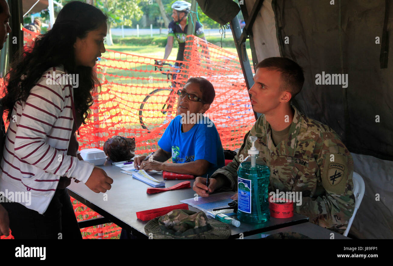 U.S. Army Cpl. Kirby Shepard, with the 399thh Tactical Psychological Operations Company, based out of San Marcos, Texas speaks with a woman before she registers for a medical readiness event during Beyond the Horizon 2017, in San Ignacio, Belize, May 15, 2017. BTH 2017 is a U.S. Southern Command-sponsored, Army South-led exercise designed to provide humanitarian and engineering services to communities in need, demonstrating U.S. support for Belize. (U.S. Army photo by Spc. Kelson Brooks) (RELEASED) Stock Photo