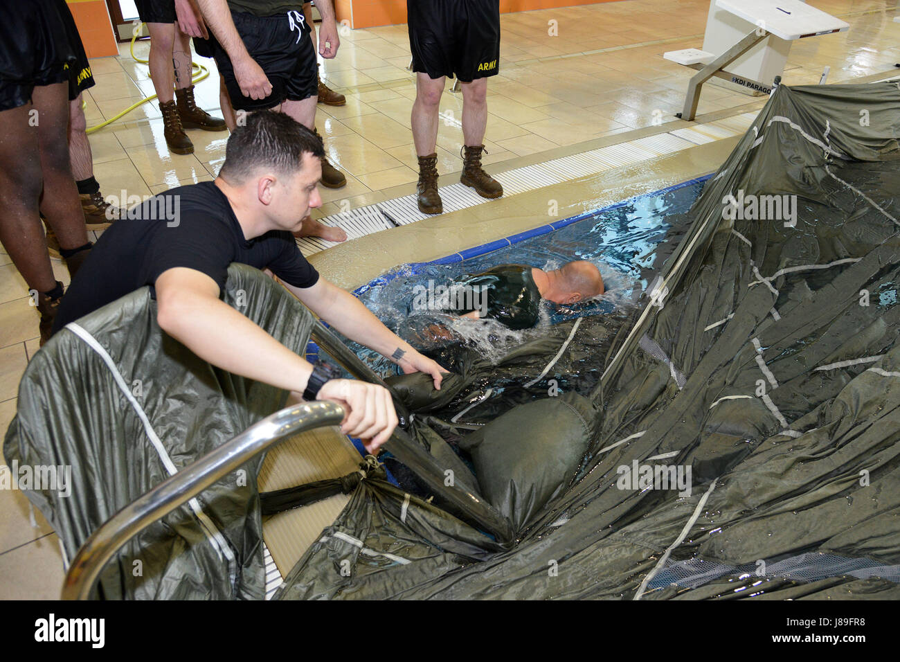 U.S. Army Paratroopers assigned 1st Battalion, 503rd Infantry Regiment, 173rd Airborne Brigade conduct Wet Silk training with Italian Army 4th Regimento Paracadutisti Alpini and 8th Reggimento Genio Guastatori Brigata Paracadutisti Folgore. During this part of the training, the U.S. and Italian Paratroopers swim under a parachute in the swimming pool at Caserma Del Din Vicenza, Italy, May 15, 2017. This exercise is part of deliberate water airborne operation familiarization training before the jump at Lake Garda, Italy. The 173rd Airborne Brigade is the U.S. Army Contingency Response Force in Stock Photo