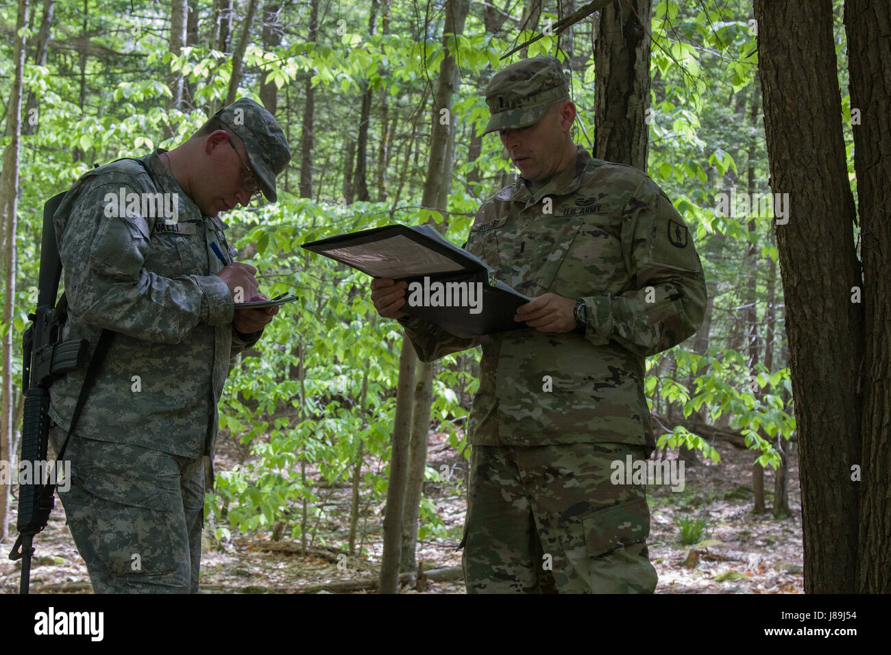 A U.S. Army officer candidate, acting as squad leader, receives operations order for a reconnaissance operations lane at New Hampshire National Guard Training Site in Center Strafford, Nh., May 19, 2017. Soldiers from Connecticut, Maine, Massachusetts, New Hampshire, New Jersey, New York, Rhode Island, and Vermont participated in the Officer Candidate School Field Leadership Exercise in preparation for graduation and commission. (U.S. Army National Guard photo by Spc. Avery Cunningham) Stock Photo