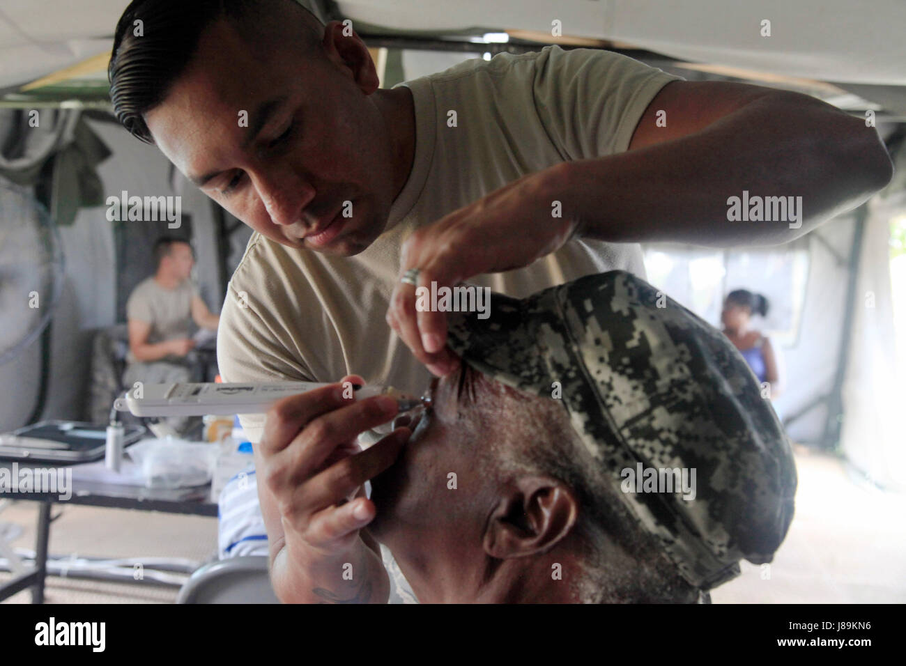 U.S. Air Force Tech Sgt. Benjamin Lemus, with the 96th Medical Support Group from Eglin Air Force Base, Florida, checks the pressure of a patient's eye at a medical readiness event in Dangriga, Belize, May 22, 2017. This is the third and final medical event for Beyond the Horizon 2017, a U.S. Southern Command-sponsored, Army South-led exercise designed to provide humanitarian and engineering services to communities in need, demonstrating U.S. support for Belize. (U.S. Army photo by Spc. Kelson Brooks) (RELEASED) Stock Photo