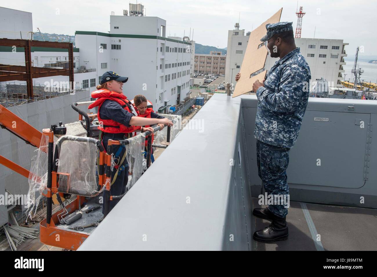 170523-N-ZL062-001 SASEBO, Japan (May 23, 2017) Sailors aboard the amphibious transport dock USS Green Bay (LPD 20) prepare to paint the Battle Effectiveness 'E' Award on the ship’s port bridgewing. Green Bay is forward-deployed to Sasebo, Japan, serving forward to provide a rapid-response capability in the event of a regional contingency or natural disaster. (U.S. Navy photo by Mass Communication Specialist Seaman Sarah Myers/Released) Stock Photo