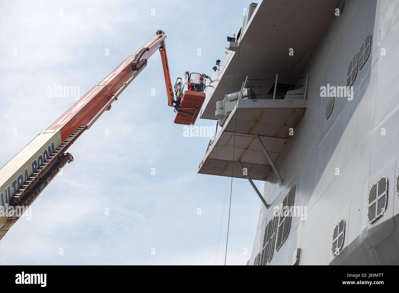 170523-N-ZL062-020 SASEBO, Japan (May 23, 2017) Sailors aboard the amphibious transport dock USS Green Bay (LPD 20) paint the Battle Effectiveness 'E' Award on the ship’s port bridgewing. Green Bay is forward-deployed to Sasebo, Japan, serving forward to provide a rapid-response capability in the event of a regional contingency or natural disaster. (U.S. Navy photo by Mass Communication Specialist Seaman Sarah Myers/Released) Stock Photo