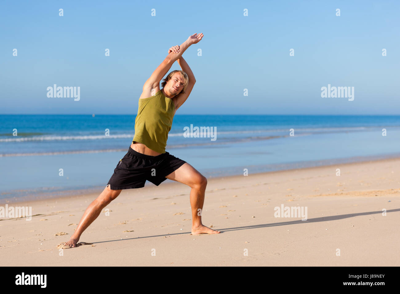 sporty man doing gymnastics on the beach Stock Photo