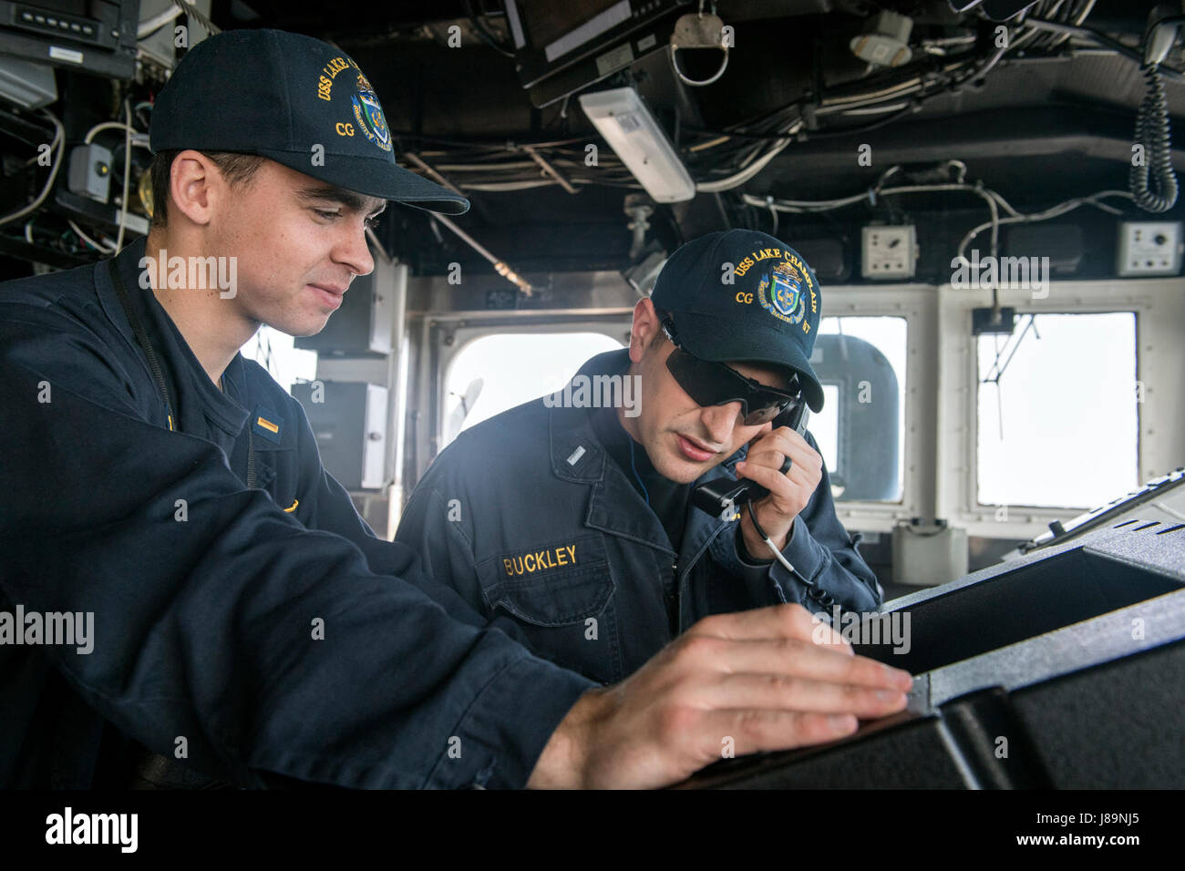 170524-N-FT178-015 WESTERN PACIFIC (May 24, 2017) Ens. John Taiclet, from St. Louis, left and Lt. j.g. Jason Buckley, from Wildwood, Mo., check for clear range before a pre-aim calibration fire exercise aboard Ticonderoga-class guided-missile cruiser USS Lake Champlain (CG 57). The U.S. Navy has patrolled the Indo-Asia-Pacific routinely for more than 70 years promoting regional peace and security. (U.S. Navy photo by Mass Communication Specialist 2nd Class Nathan K. Serpico/Released) Stock Photo