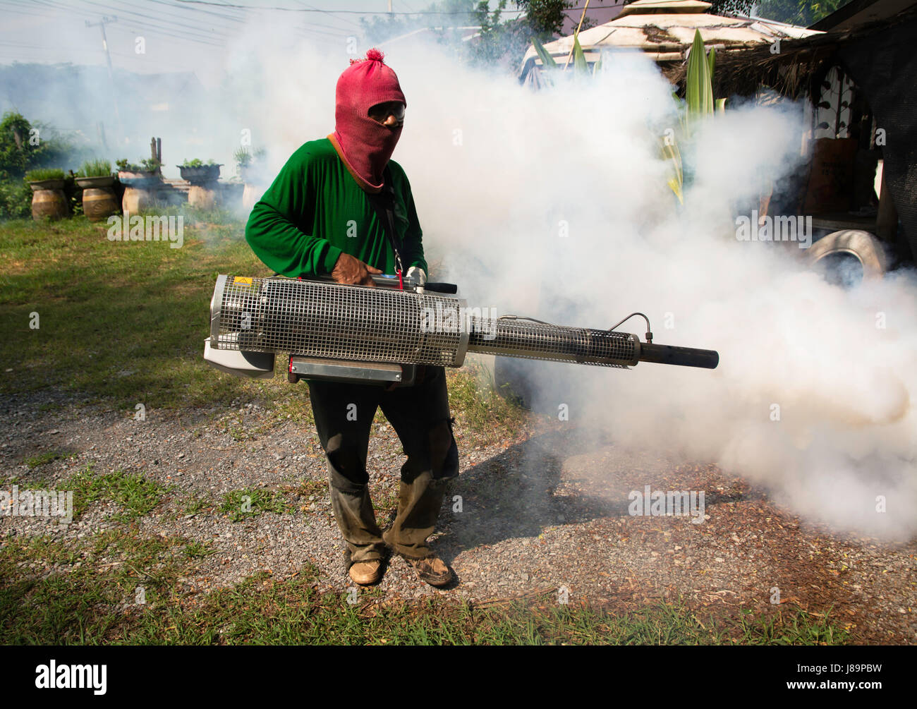 Man work fogging to eliminate mosquito for preventing spread dengue fever in Thailand. Stock Photo