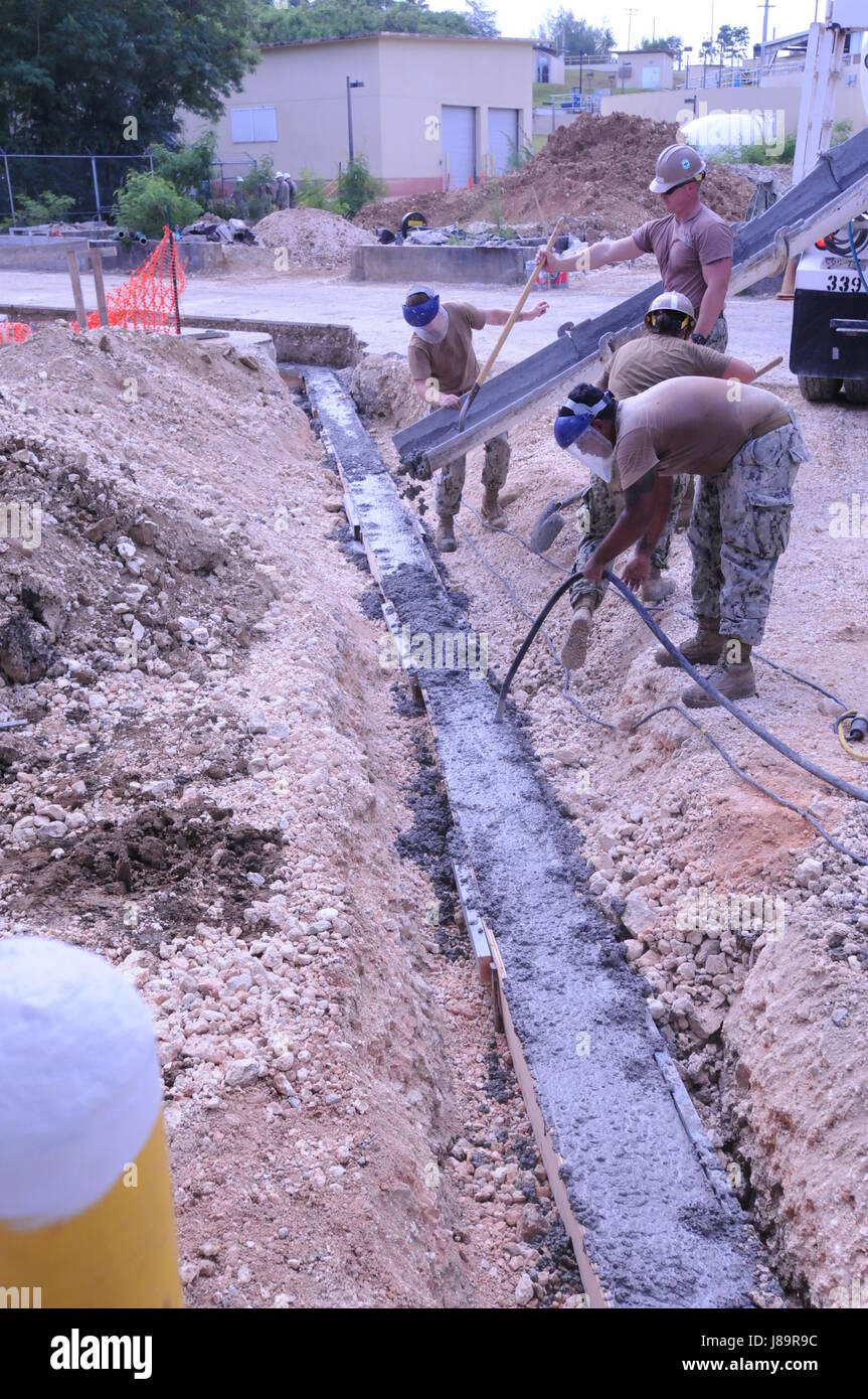 SANTA RITA, Guam (May 26, 2017) Members attached to Naval Mobile Construction Battalion 1 place concrete at the NMCB 1 Fena Water Treatment Storage Building project at Naval Station Guam, May 26, 2017. NMCB 1 is forward deployed to execute construction, humanitarian and foreign assistance, special operations combat service support, and theater security cooperation in support of U.S. Pacific Command. (U.S. Navy photo by Steelworker 2nd Class Emily Garza) Stock Photo