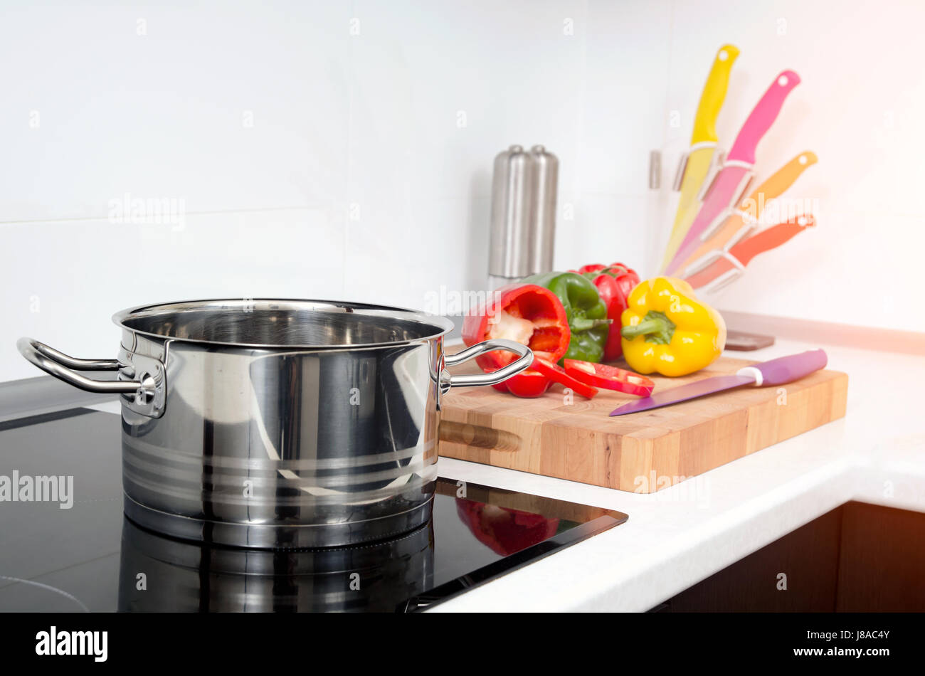 Pot and vegetables in modern kitchen with induction stove. stove cooker hob kitchen pot pan steel gourmet concept Stock Photo