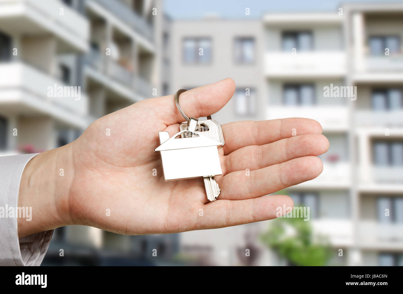 Man hand holding keys with to new house. Home shape chrome pendant ...