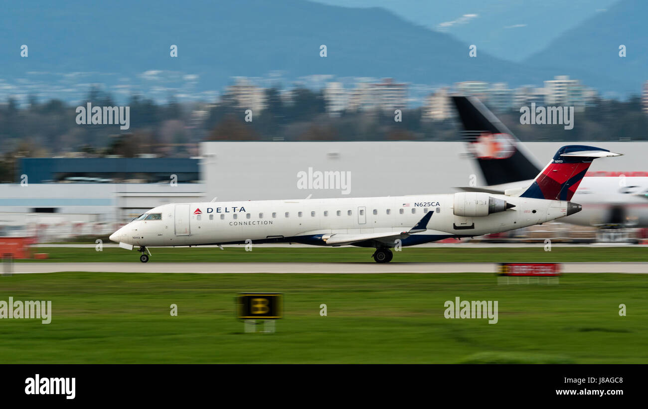 Delta Connection (SkyWest Airlines) Bombardier CRJ-700 regional jet takes off from Vancouver International Airport Stock Photo