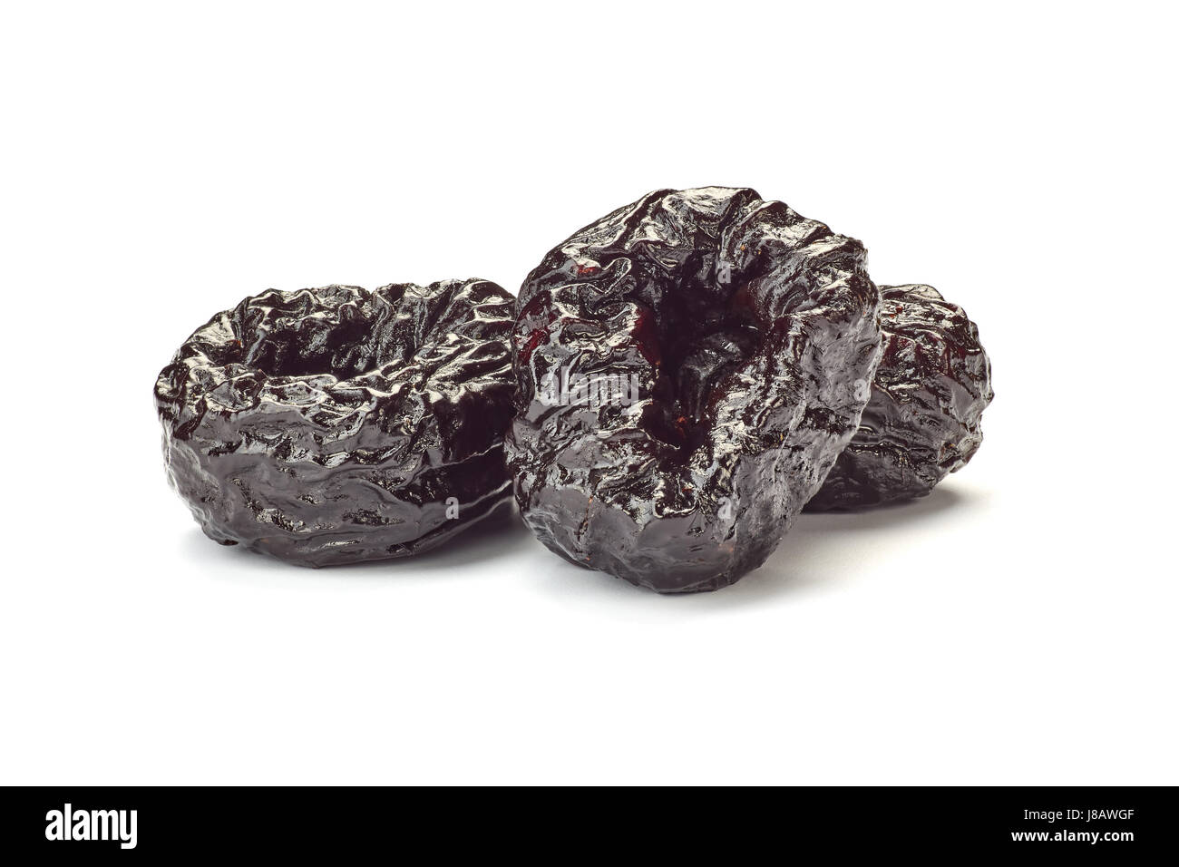 Three dried plums on white Stock Photo