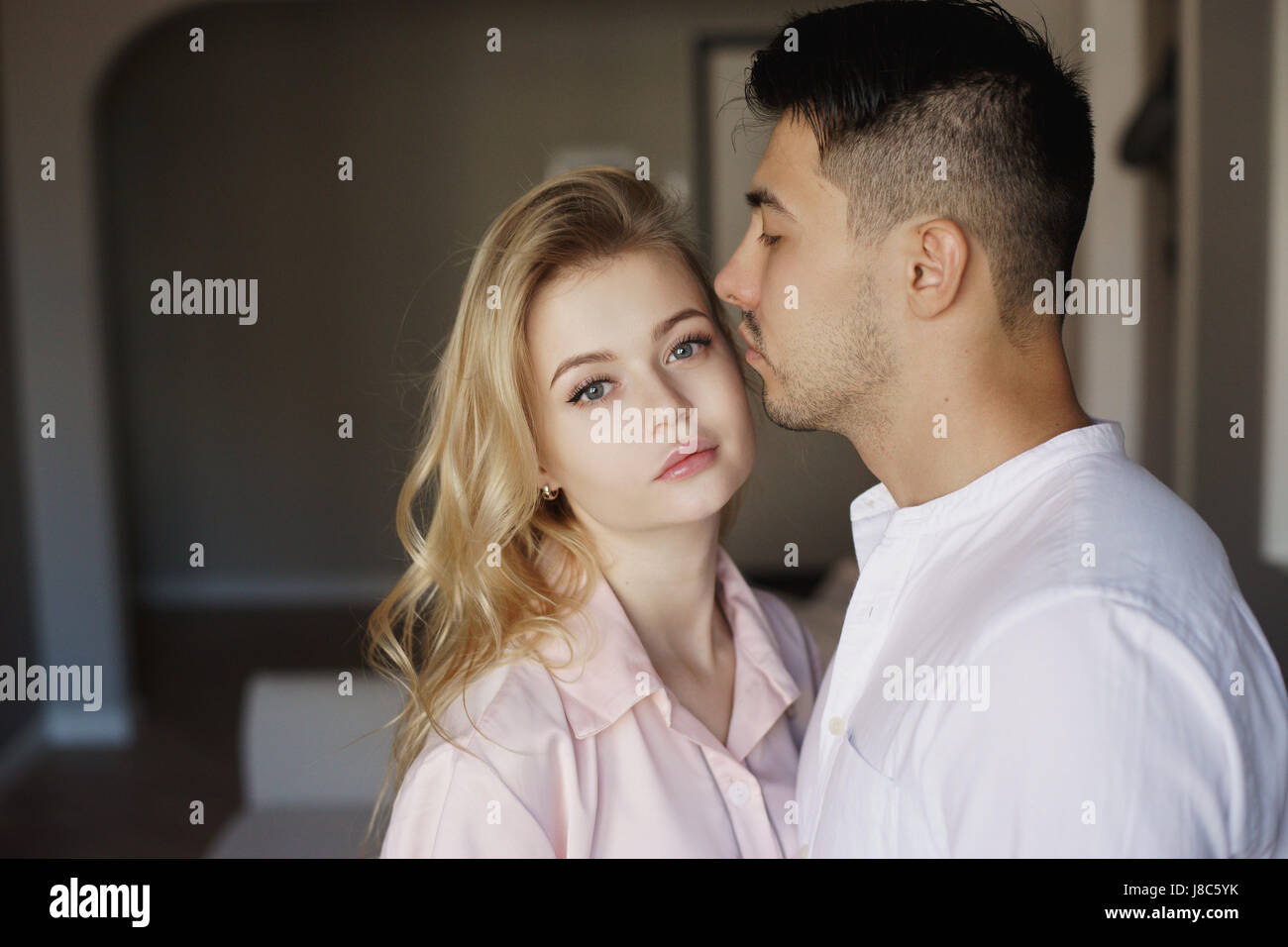 Young romantic couple at home. Caucasian blonde woman and brunette man ...