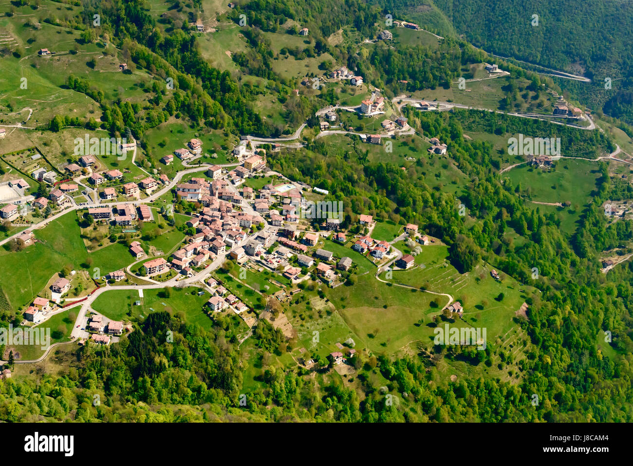 aerial shot, from a small plane, of Gerosa village, shot on a bright springtime day in Brembilla valley, Lombardy , Italy Stock Photo