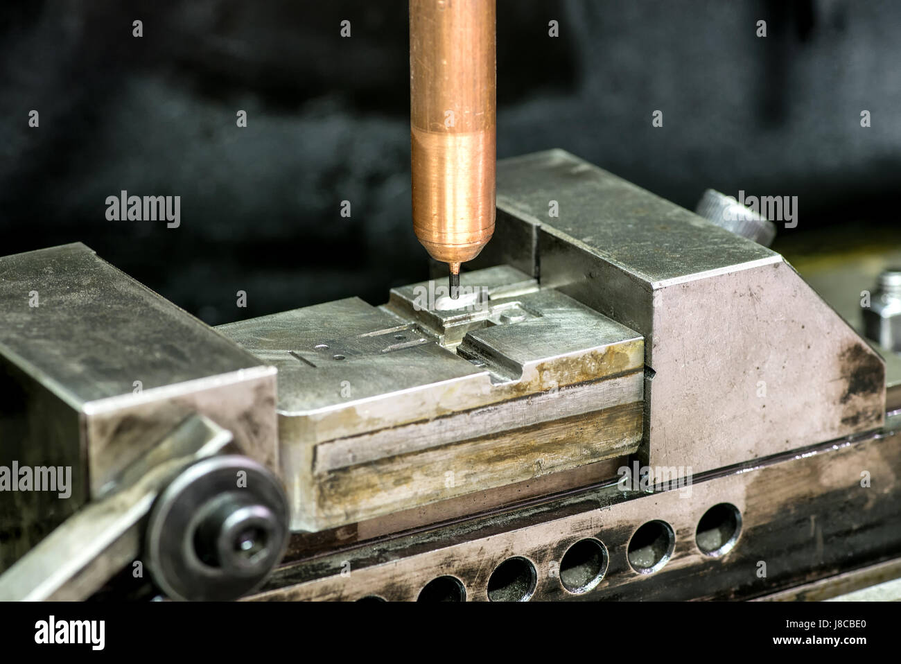 Automatic drilling machine in close-up working on producing metal mold Stock Photo