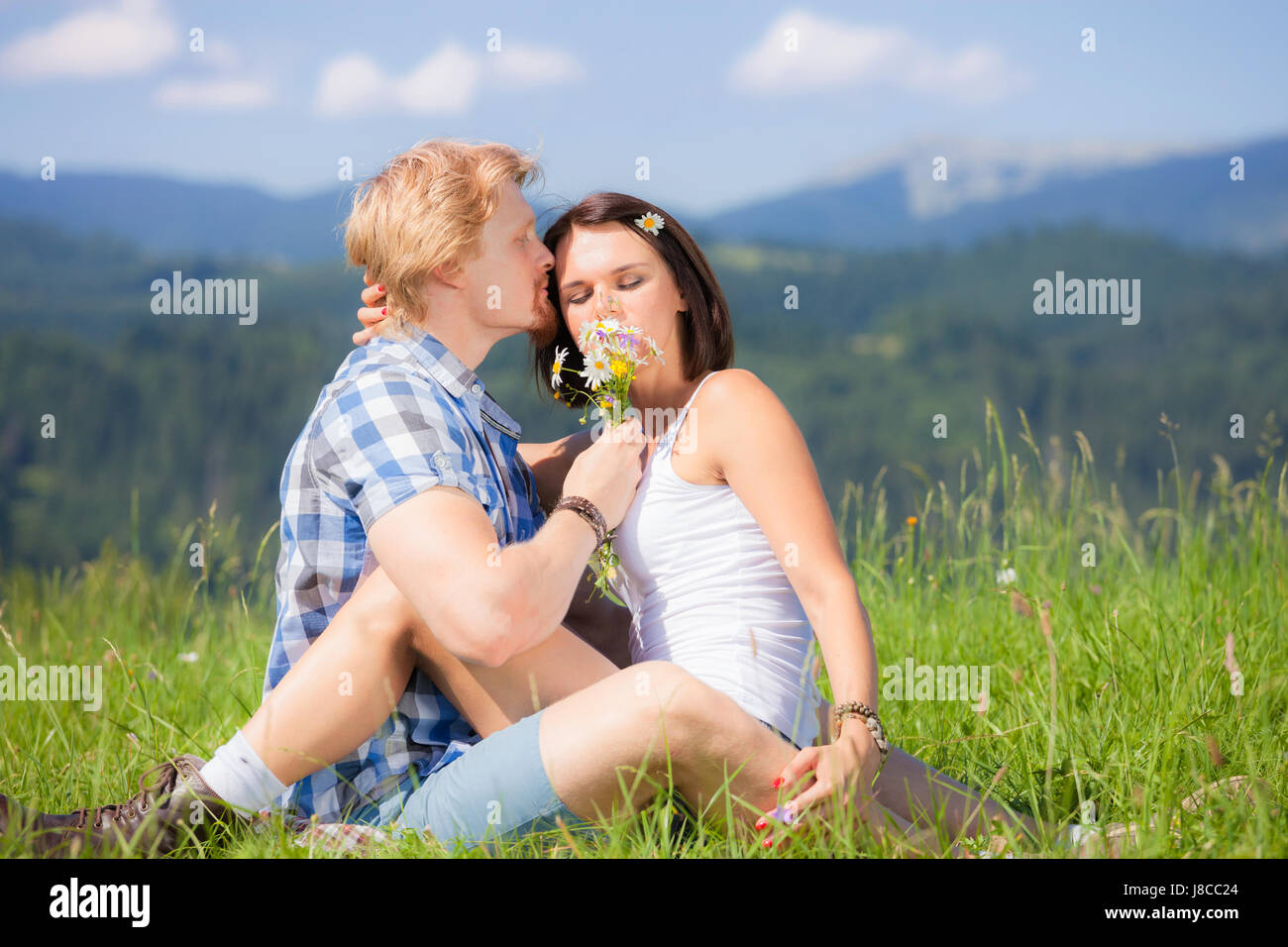 Happy beautiful couple in love on the green grass field Stock Photo - Alamy