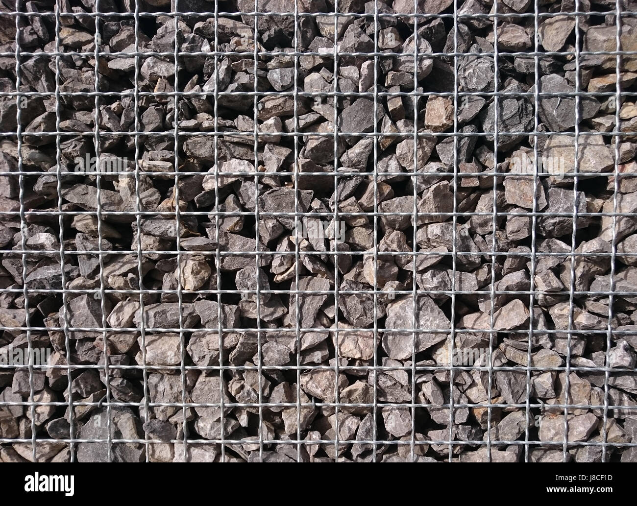 Stone fence in wire frame Stock Photo