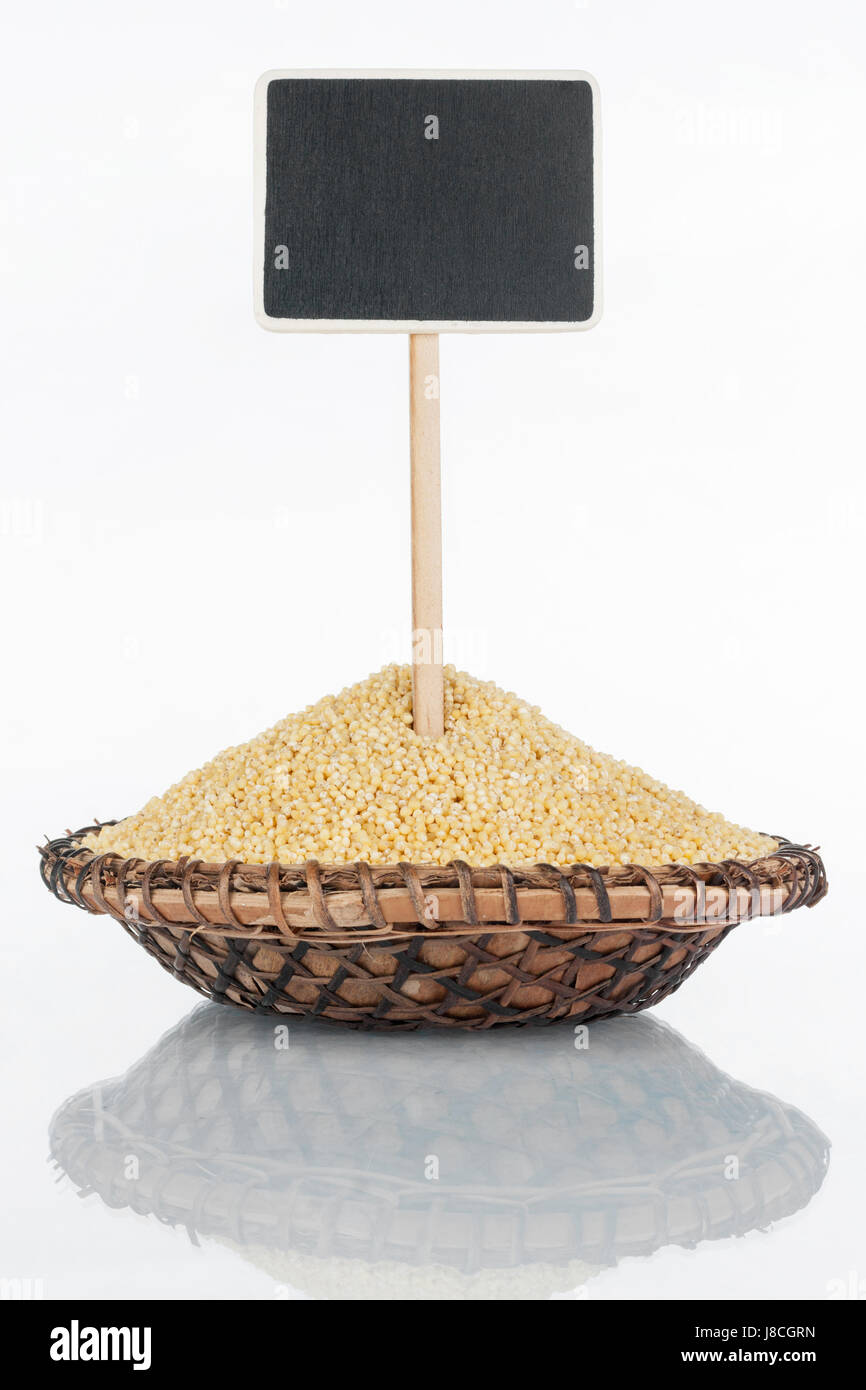Plate with a bunch of millet grains and its reflection and price tag, pointer. With a place for your text Stock Photo