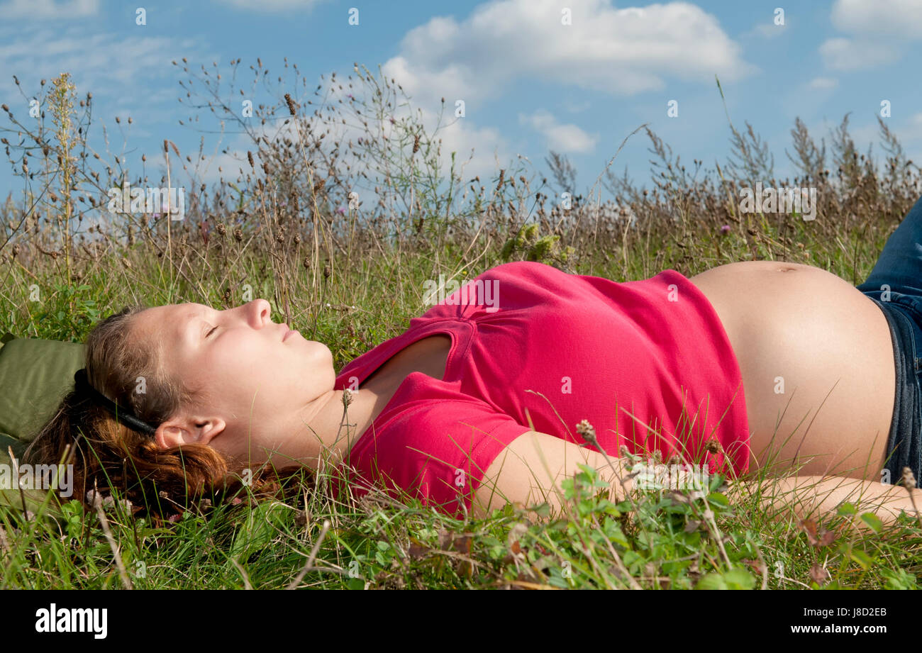 pregnant young woman relaxing on a meadow Stock Photo