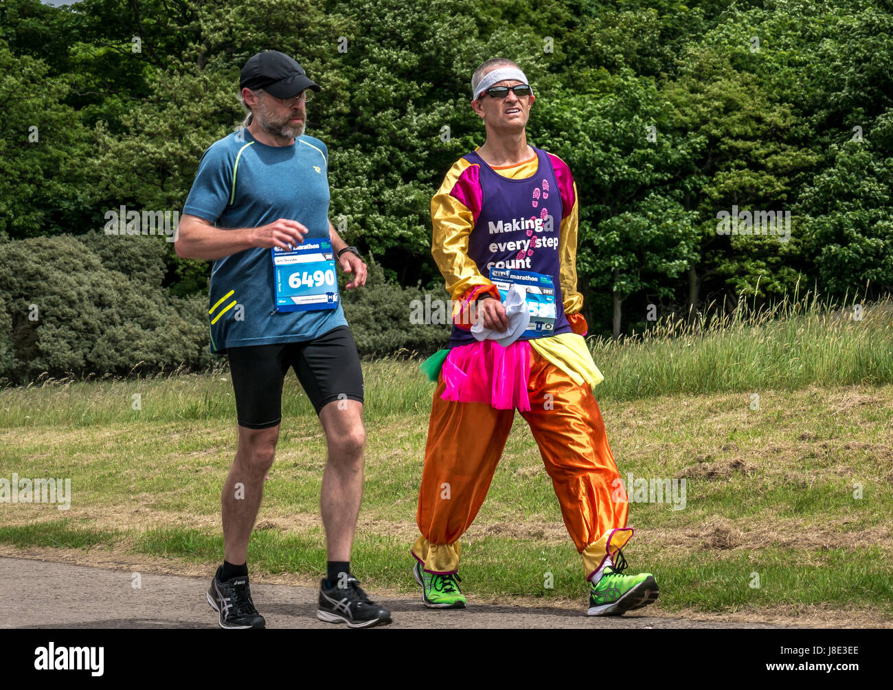 Gosford Estate, East Lothian, Scotland, UK. 28th May, 2017. A man in fancy dress clown costume participating in the Edinburgh Marathon Festival 2017 taking a rest walking Stock Photo