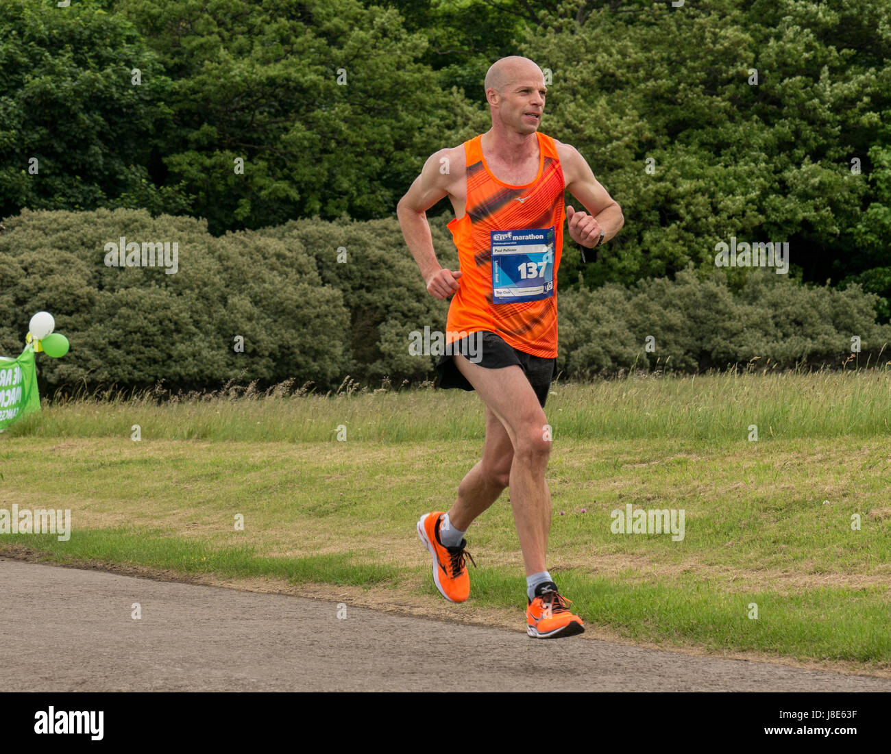 Gosford Estate, East Lothian, Scotland, UK. 28th May, 2017. Male runner, Paul Pallister, in orange vest and shoes at Mile 18 at Edinburgh Marathon Festival 2017. Paul was placed in the top 50 finishers Stock Photo