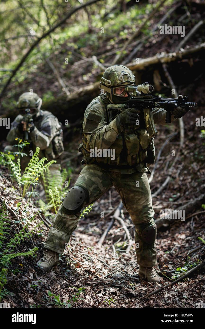 Group of soldiers on military operation in afternoon at forest Stock Photo