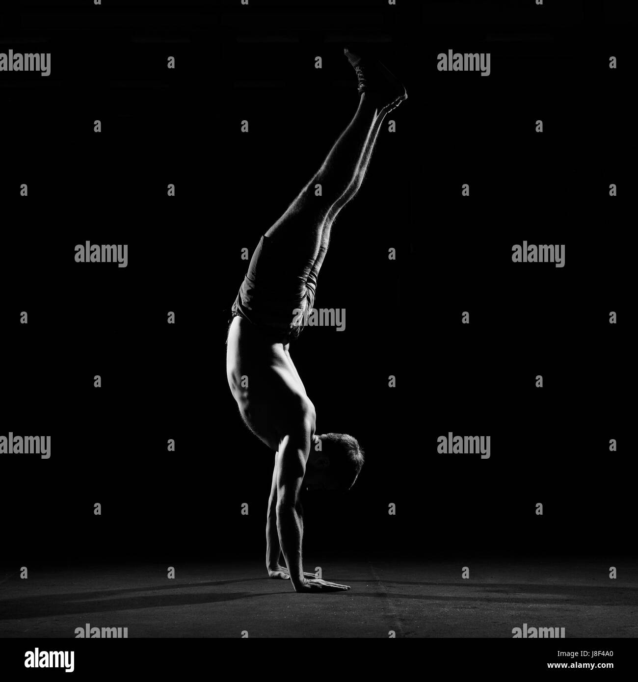 Fitness training. Male athlete walking on his hands or standing upside ...