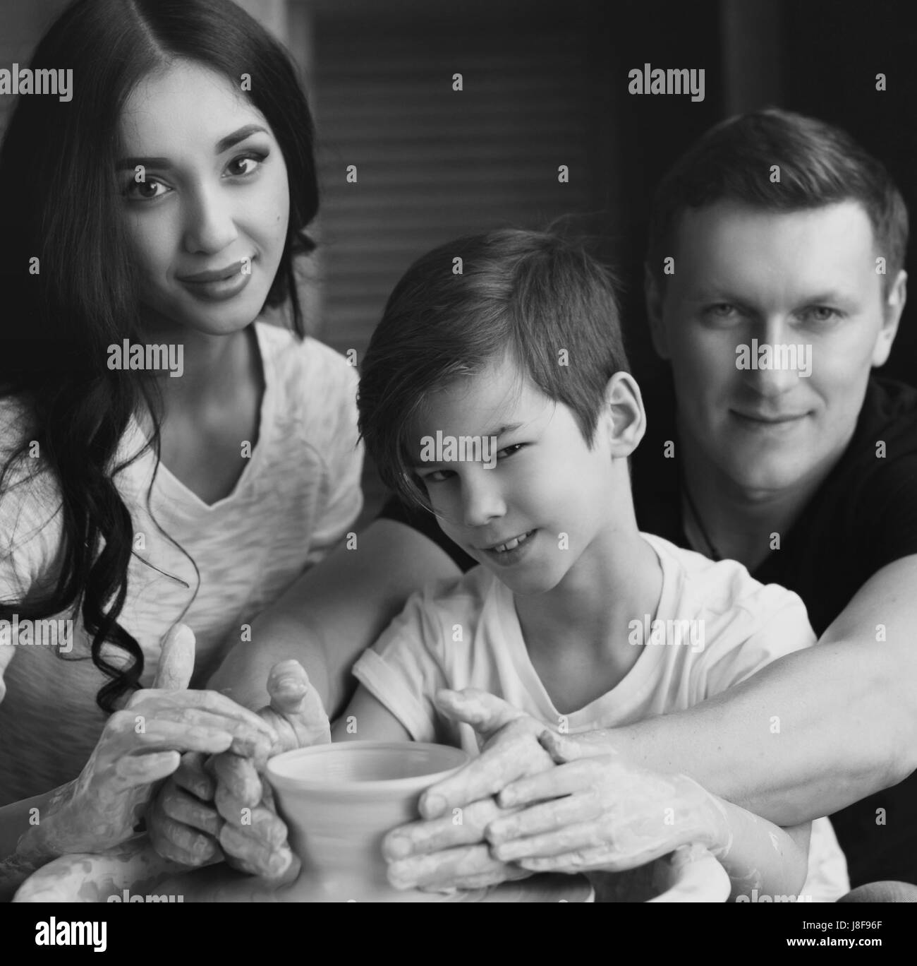 Family working on pottery wheel. Handsome father and beautiful mother ...
