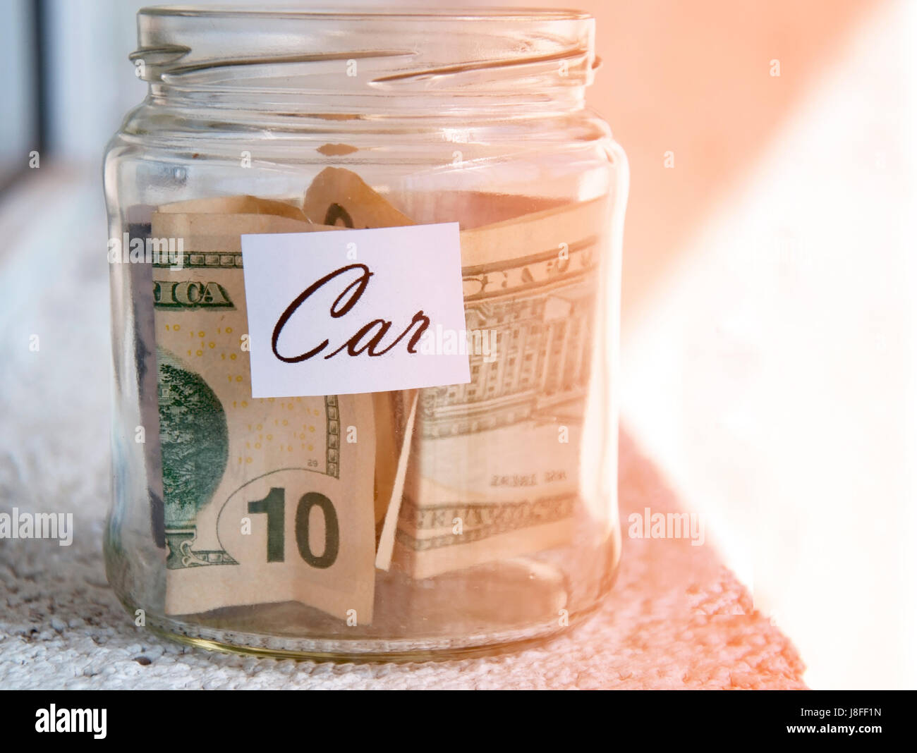 A glass jar with money with the inscription "car Stock Photo Alamy