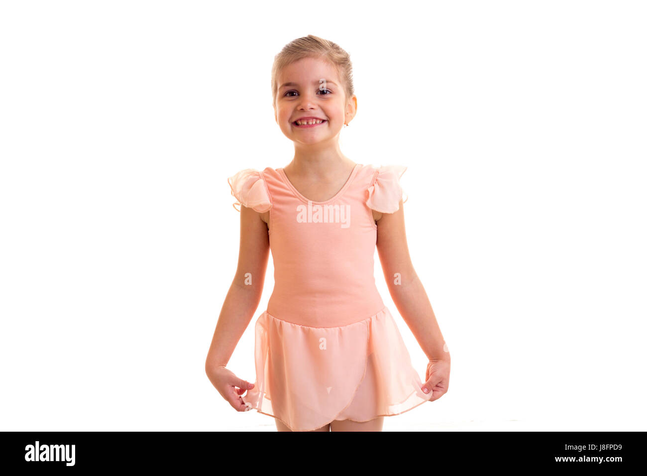 Little optimistic girl in pink dress dancing on white background in